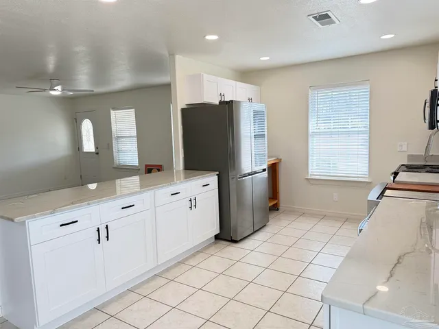 a kitchen with kitchen island a stove a sink and a microwave