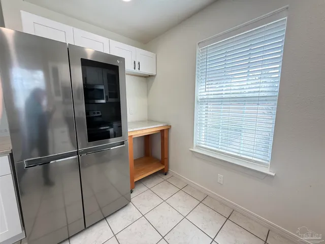 a kitchen with white cabinets and appliances