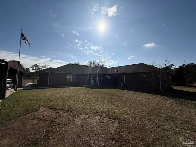 a white house with a big yard and large trees