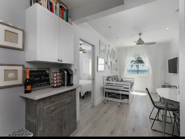 a kitchen with stainless steel appliances kitchen island granite countertop a stove a refrigerator and a dining table with wooden floor