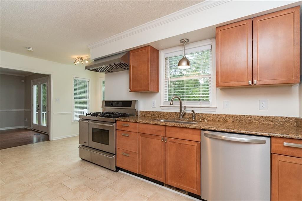 9317 Meadow Rue Place Raleigh, NC 27603 - Photo 11 of 36 a kitchen with granite countertop stainless steel appliances a stove sink and microwave