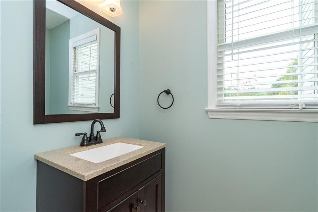 9317 Meadow Rue Place Raleigh, NC 27603 - Photo 14 of 36 a bathroom with a sink a mirror and a window