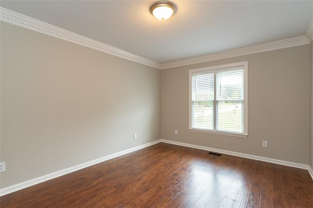 9317 Meadow Rue Place Raleigh, NC 27603 - Photo 16 of 36 an empty room with wooden floor and windows