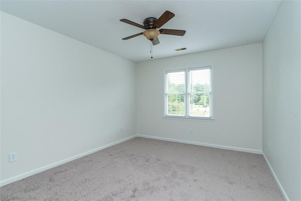 9317 Meadow Rue Place Raleigh, NC 27603 - Photo 19 of 36 an empty room with a window and a fan