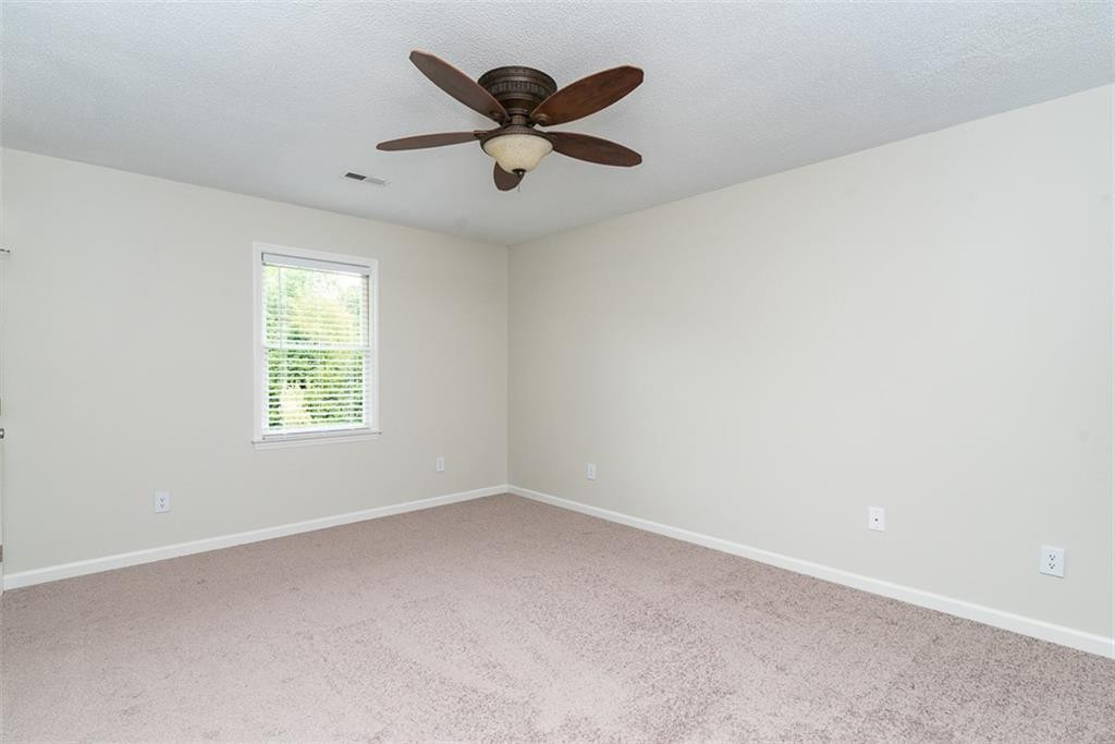 9317 Meadow Rue Place Raleigh, NC 27603 - Photo 22 of 36 an empty room with ceiling fan and windows