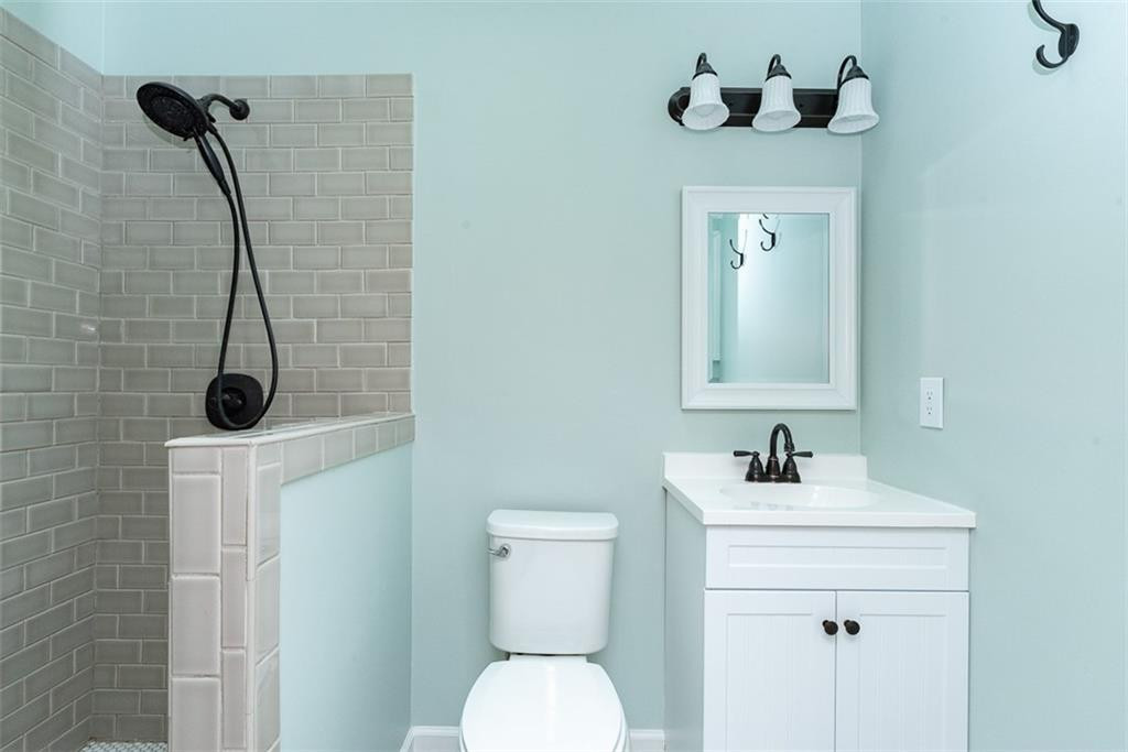 9317 Meadow Rue Place Raleigh, NC 27603 - Photo 24 of 36 a bathroom with a sink a toilet and a mirror