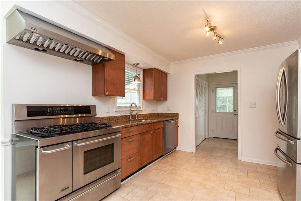 9317 Meadow Rue Place Raleigh, NC 27603 - Photo 10 of 36 a kitchen with stainless steel appliances granite countertop a stove a sink and a refrigerator