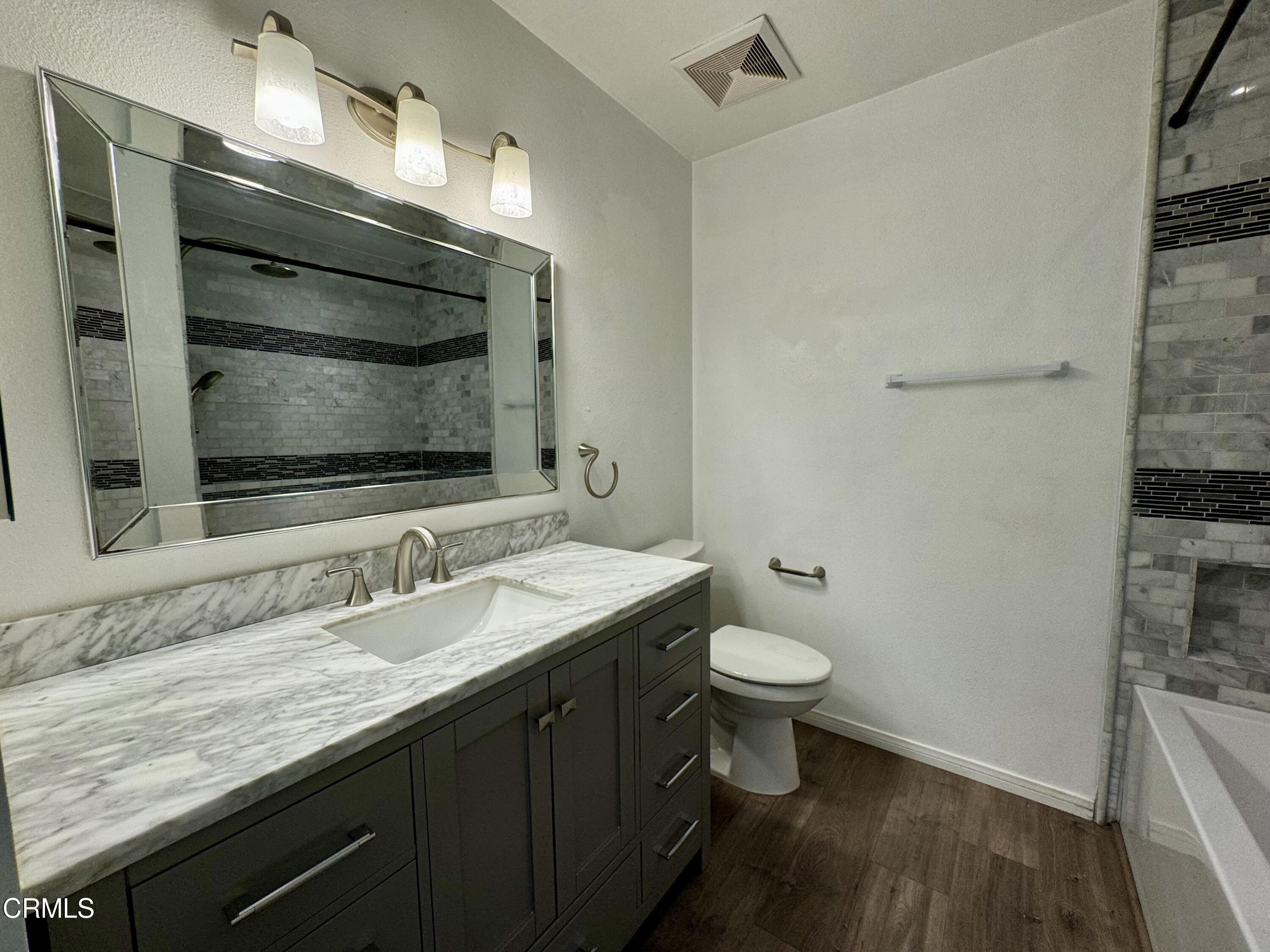 1031 Dunes Street, Unit D Oxnard, CA 93035 - Photo 8 of 26 a bathroom with a granite countertop toilet sink and mirror