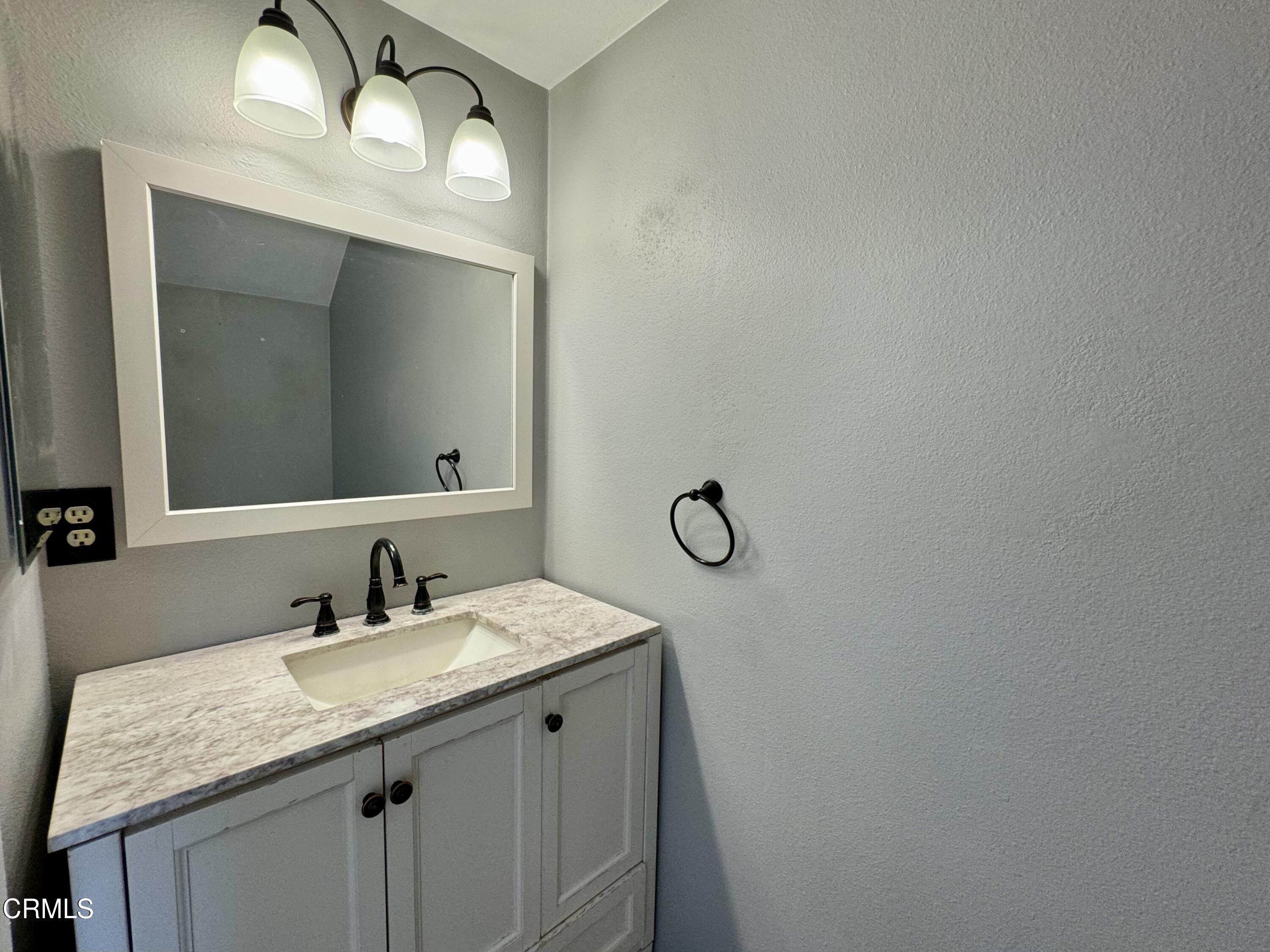 1031 Dunes Street, Unit D Oxnard, CA 93035 - Photo 10 of 26 a bathroom with a granite countertop sink and a mirror
