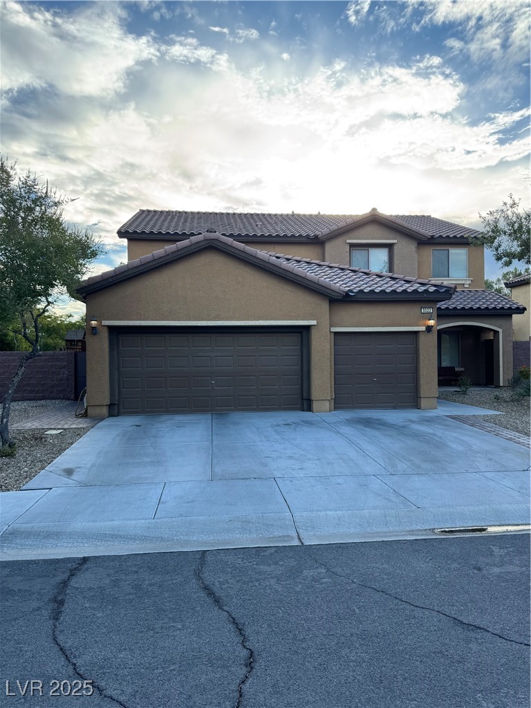 5522 Porcupine Rim Street Las Vegas, NV 89130 - Photo 1 of 28 Traditional-style house with concrete driveway, stucco siding, a garage, and a tile roof