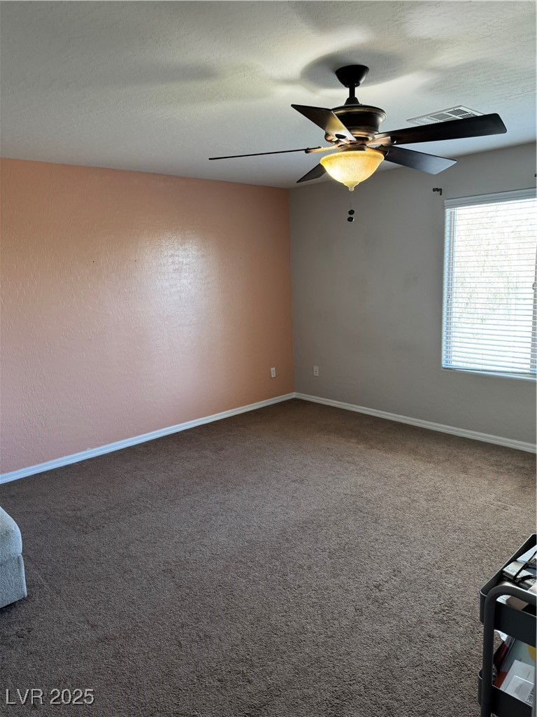 5522 Porcupine Rim Street Las Vegas, NV 89130 - Photo 13 of 28 Empty room featuring dark carpet, a textured ceiling, and ceiling fan