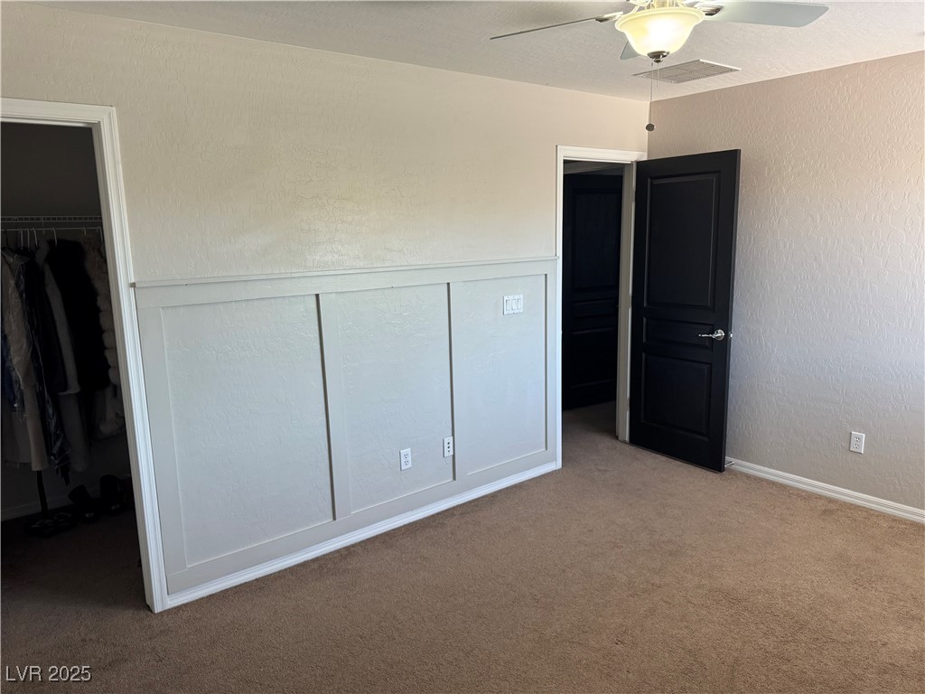 5522 Porcupine Rim Street Las Vegas, NV 89130 - Photo 18 of 28 Unfurnished bedroom with a spacious closet, carpet flooring, a textured wall, and ceiling fan