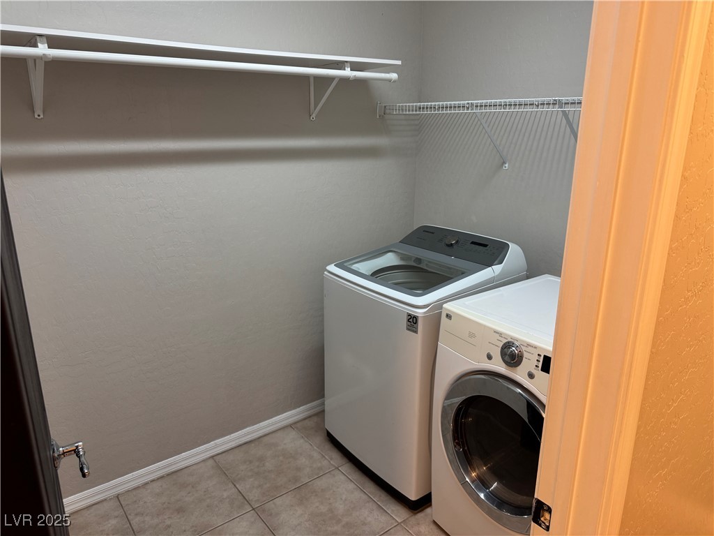 5522 Porcupine Rim Street Las Vegas, NV 89130 - Photo 20 of 28 Laundry area with light tile patterned floors and washer and clothes dryer