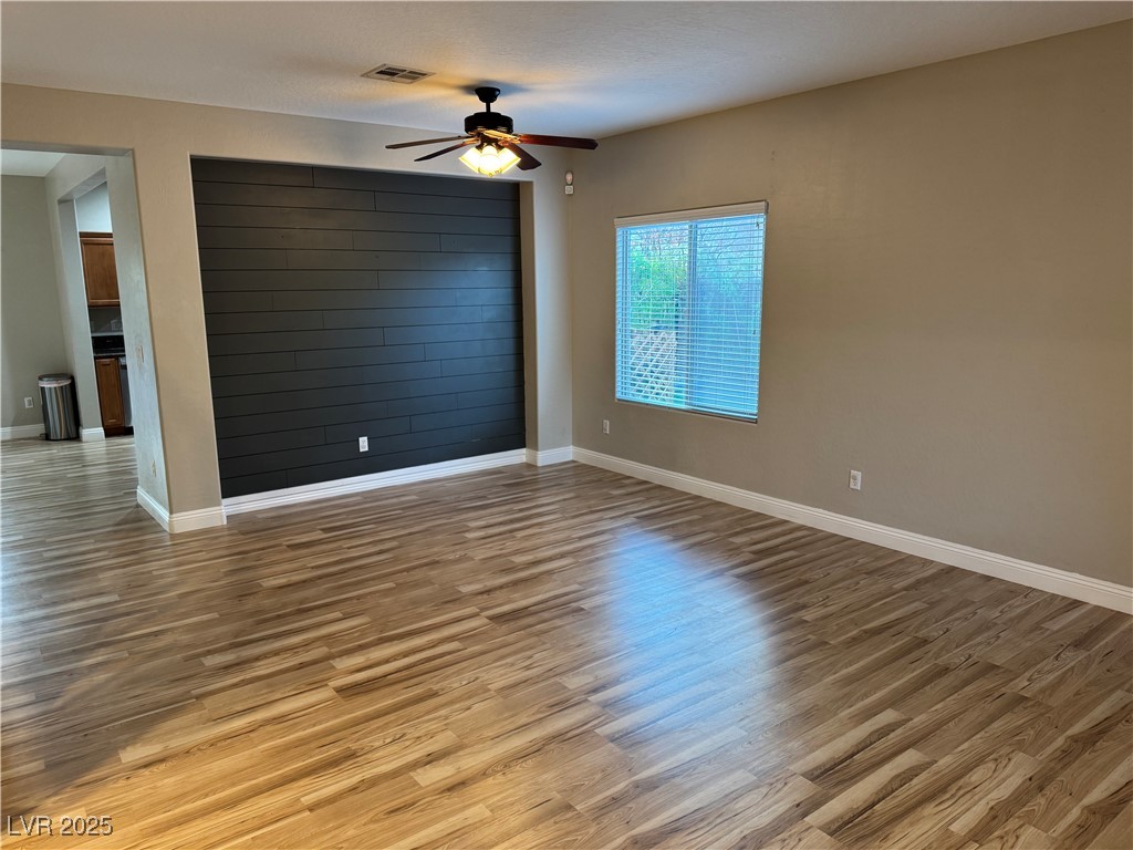 5522 Porcupine Rim Street Las Vegas, NV 89130 - Photo 6 of 28 Empty room with light wood finished floors and a ceiling fan