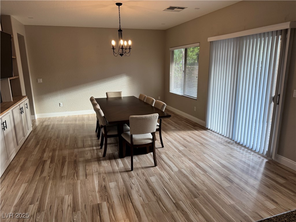 5522 Porcupine Rim Street Las Vegas, NV 89130 - Photo 7 of 28 Dining space with light wood finished floors and a chandelier