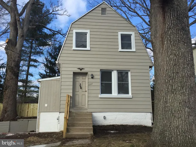 a front view of a house with a tree