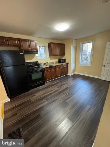 a kitchen with stainless steel appliances kitchen island granite countertop a stove a sink and a refrigerator