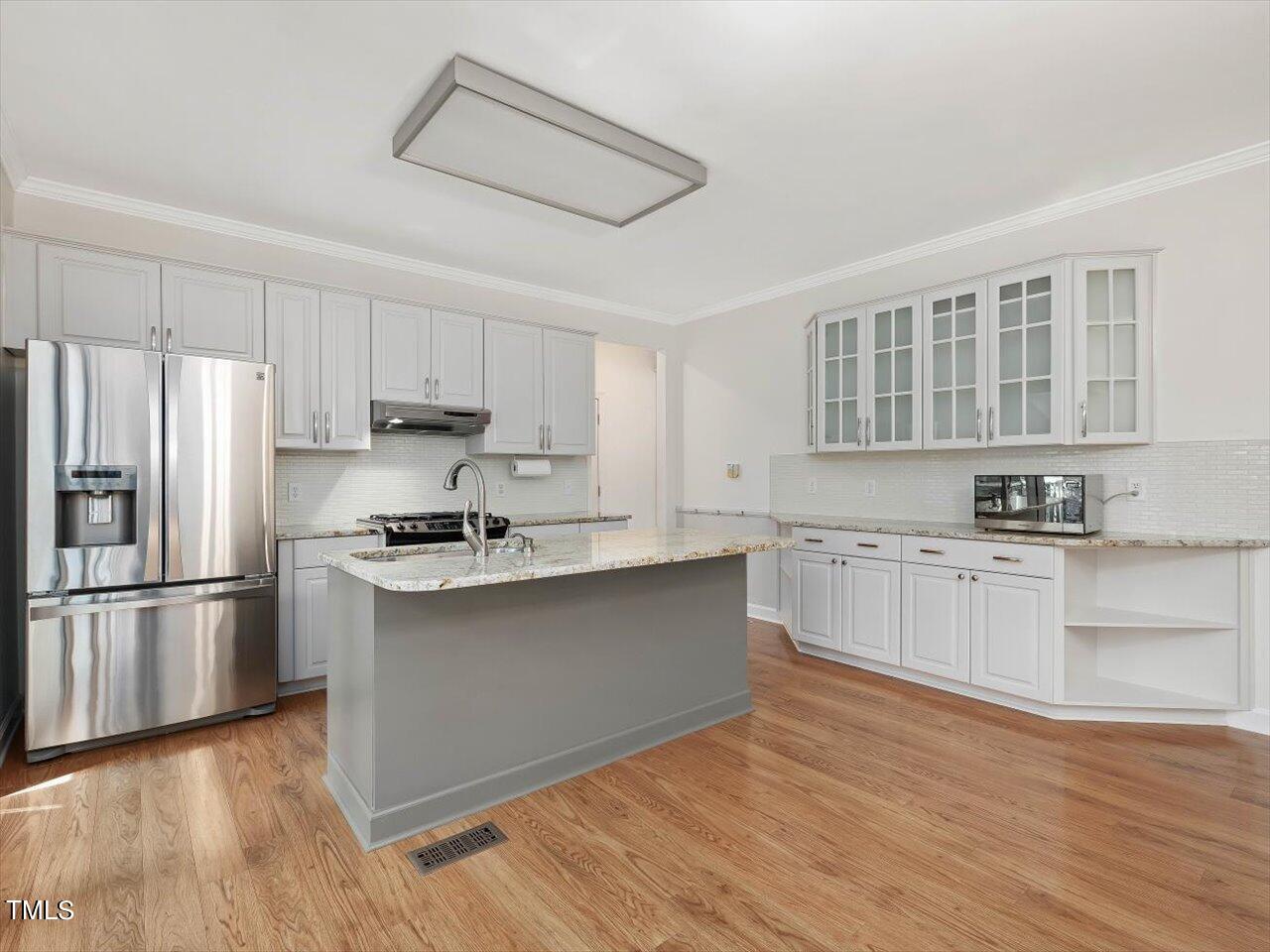 7001 Three Bridges Circle Raleigh, NC 27613 - Photo 4 of 25 a kitchen with stainless steel appliances granite countertop a refrigerator sink and white cabinets
