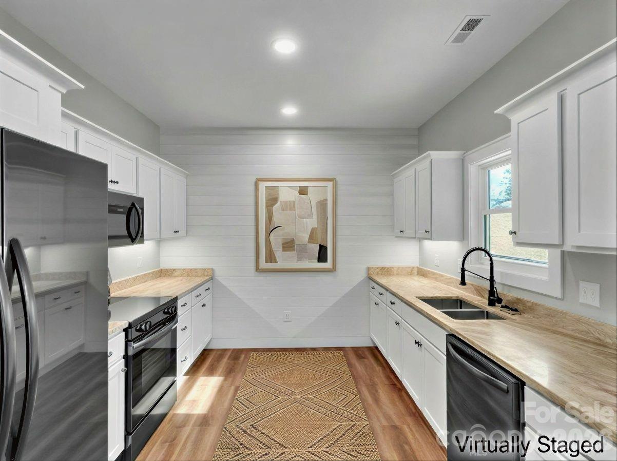 171 Peyton Elaine Road Clyde, NC 28721 - Photo 9 of 25 a large kitchen with granite countertop a sink stainless steel appliances and cabinets