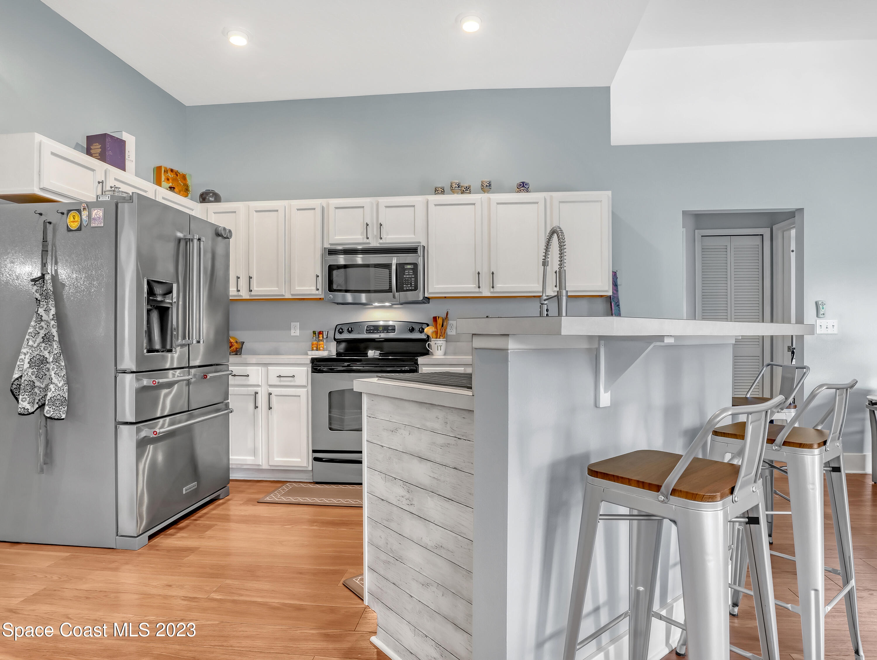 1025 Oak Tree Place Malabar, FL 32950 - Photo 14 of 33 a kitchen with stainless steel appliances and white cabinets