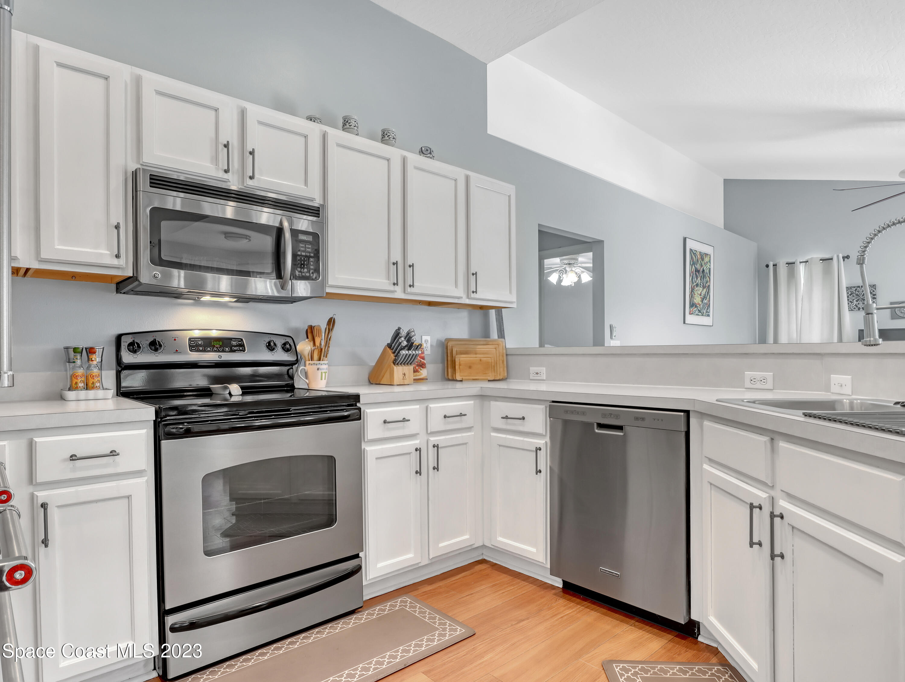 1025 Oak Tree Place Malabar, FL 32950 - Photo 15 of 33 a kitchen with cabinets stainless steel appliances and wooden floor