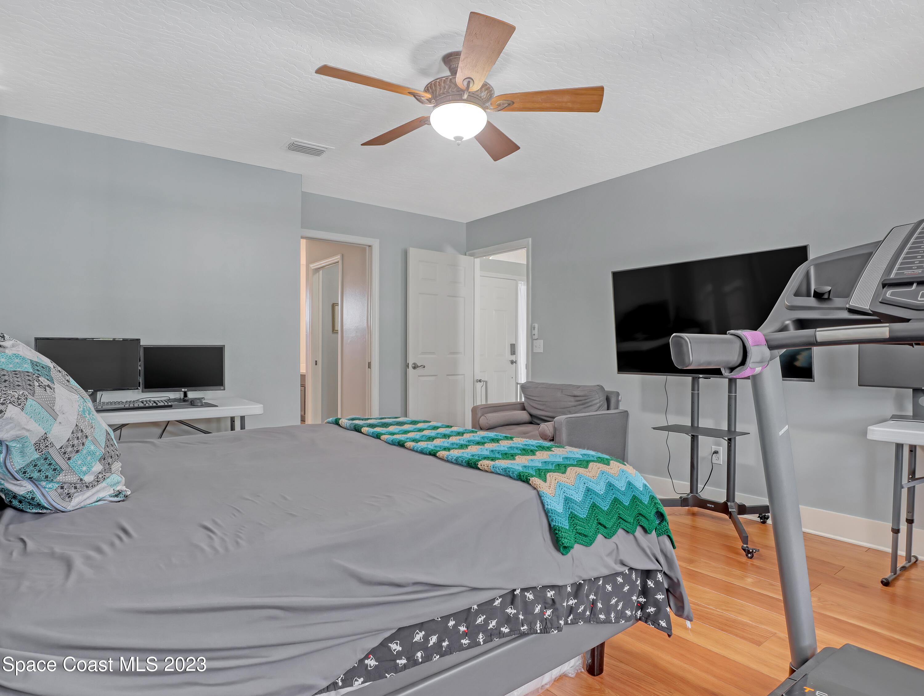 1025 Oak Tree Place Malabar, FL 32950 - Photo 21 of 33 a bed sitting in a bedroom and a flat screen tv