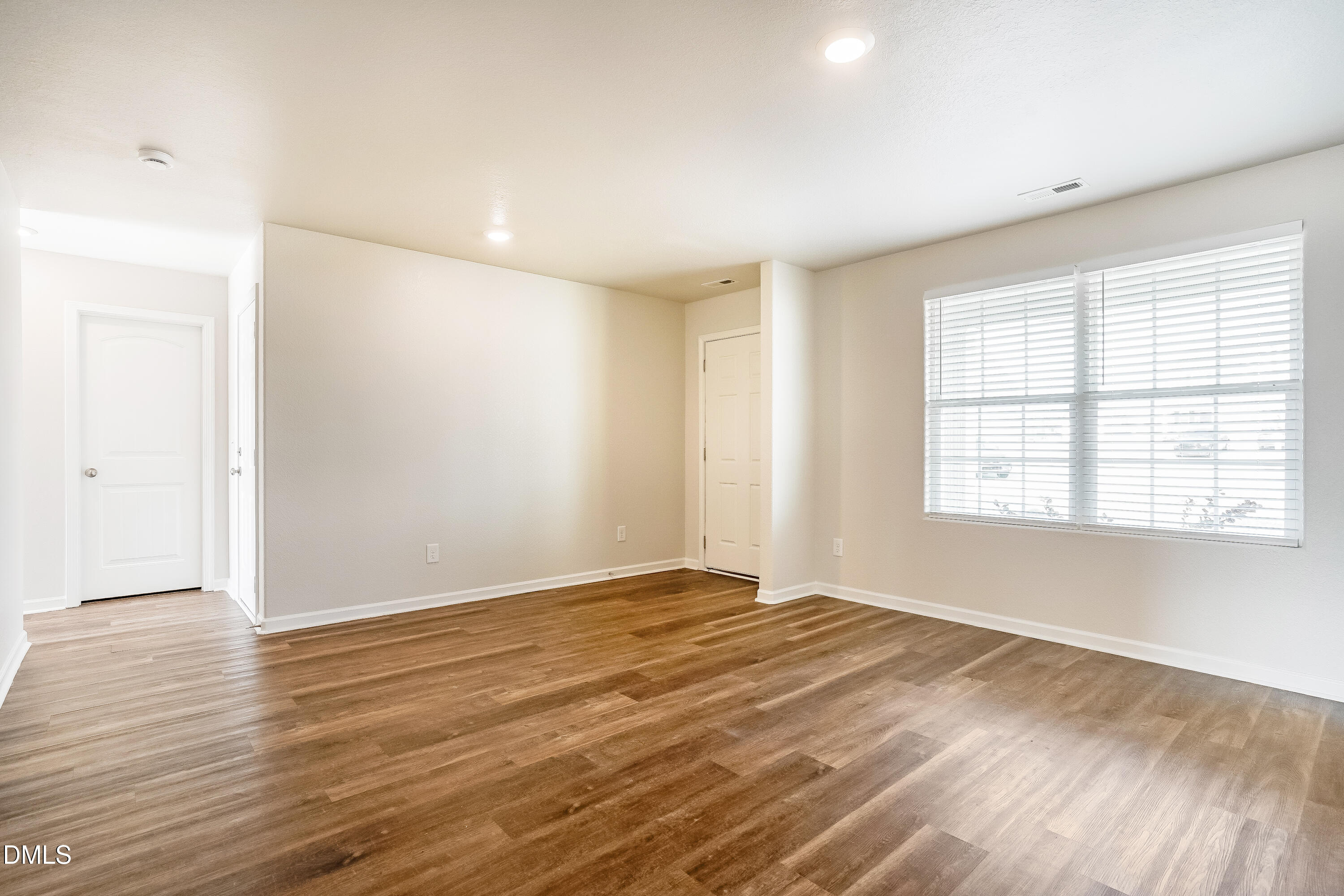 124 Lahinch Drive Fuquay-Varina, NC 27526 - Photo 4 of 17 a view of an empty room with wooden floor and a window