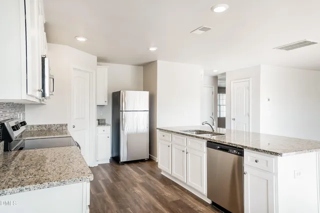 a kitchen with stainless steel appliances granite countertop a sink and a refrigerator