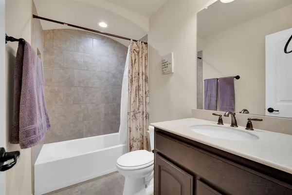 a bathroom with a sink a toilet a mirror a bathtub and shower