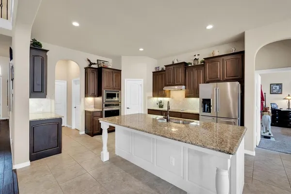 a kitchen with stainless steel appliances granite countertop a refrigerator and a sink