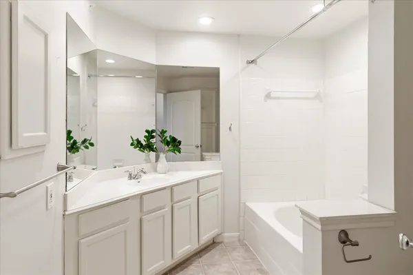 a bathroom with a tub sink and mirror