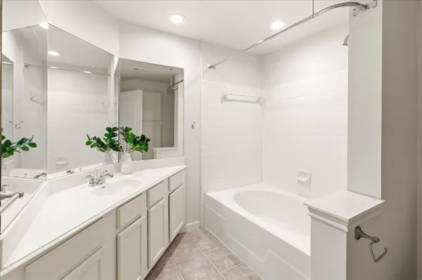 a bathroom with a bathtub shower sink and mirror