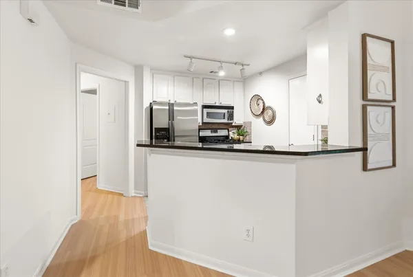 a kitchen with stainless steel appliances granite countertop a refrigerator and a microwave