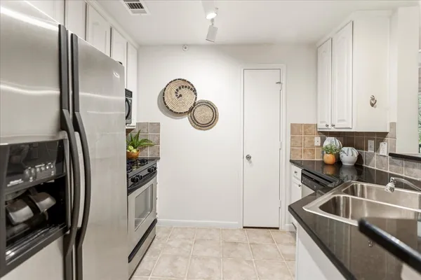 a kitchen with stainless steel appliances granite countertop a refrigerator and a sink