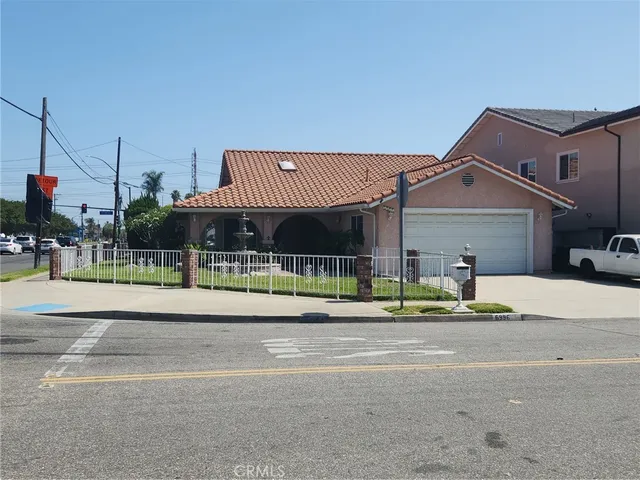 a front view of a house with a garden and plants