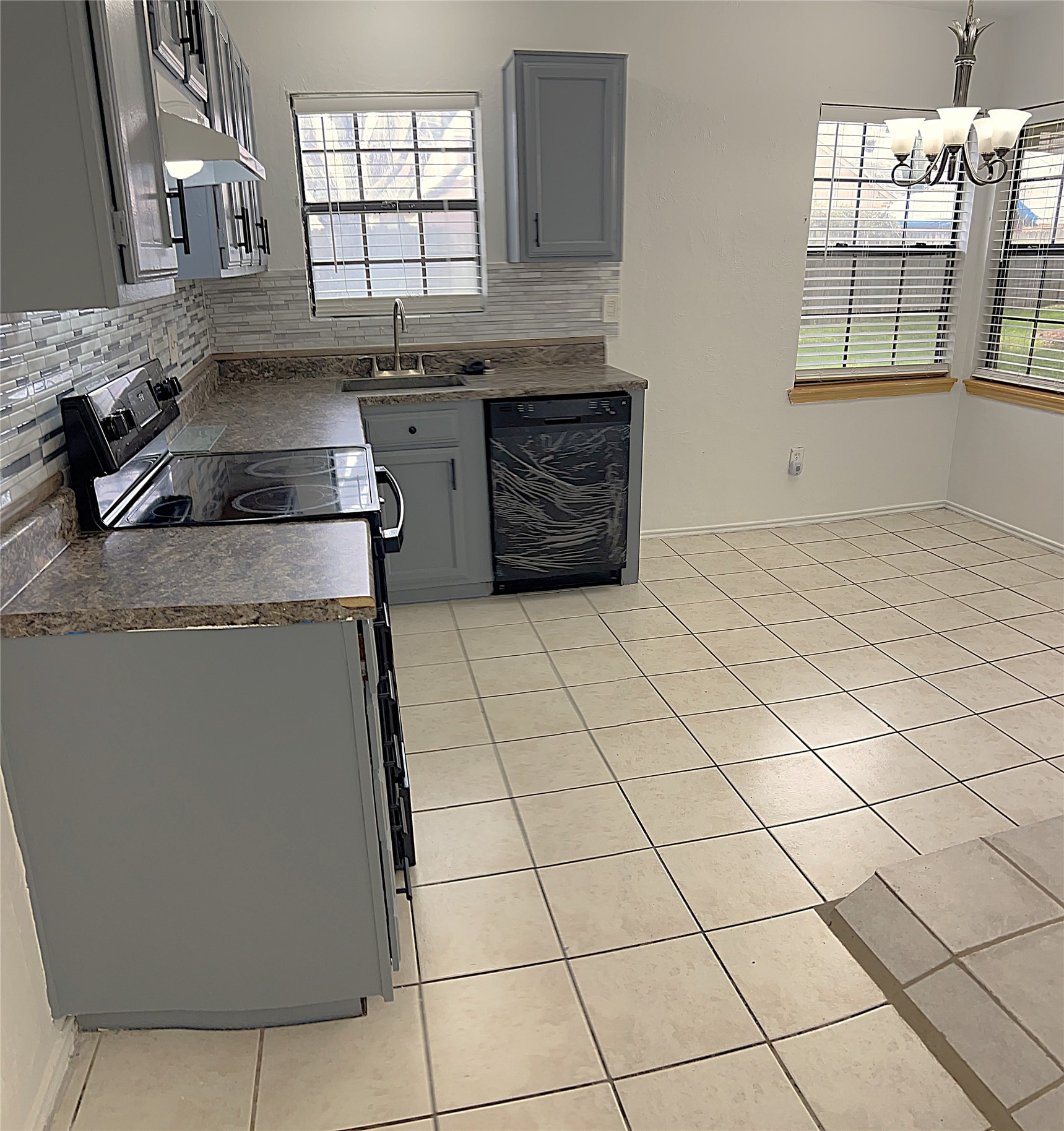 19906 Rising Star Drive Humble, TX 77338 - Photo 13 of 32 a kitchen with granite countertop a sink a stove and cabinets