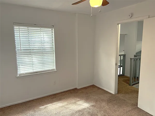 an empty room with a window and a bathroom