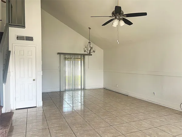 an empty room with fan and windows