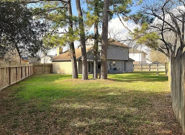 a view of a house with backyard and tree