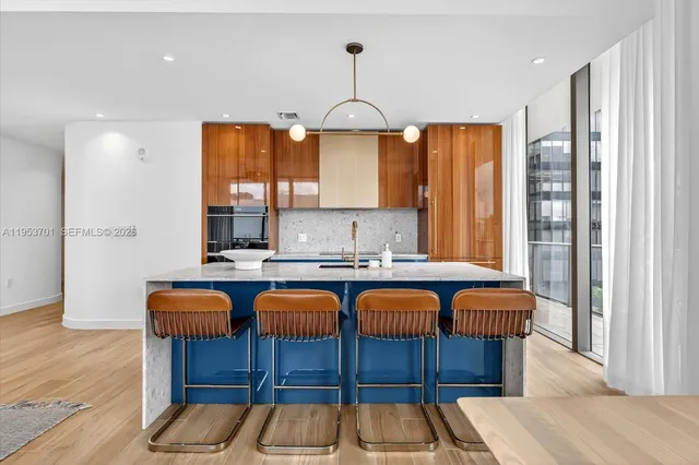 a kitchen with stainless steel appliances granite countertop wooden floor window dining table and chairs