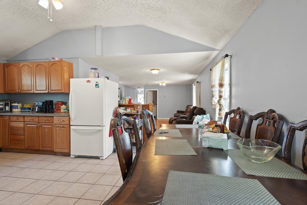 74 Chestnut Street Chelsea, MA 02150 - Photo 12 of 37 a view of a kitchen and dining room with furniture wooden floor carpet and a chandelier