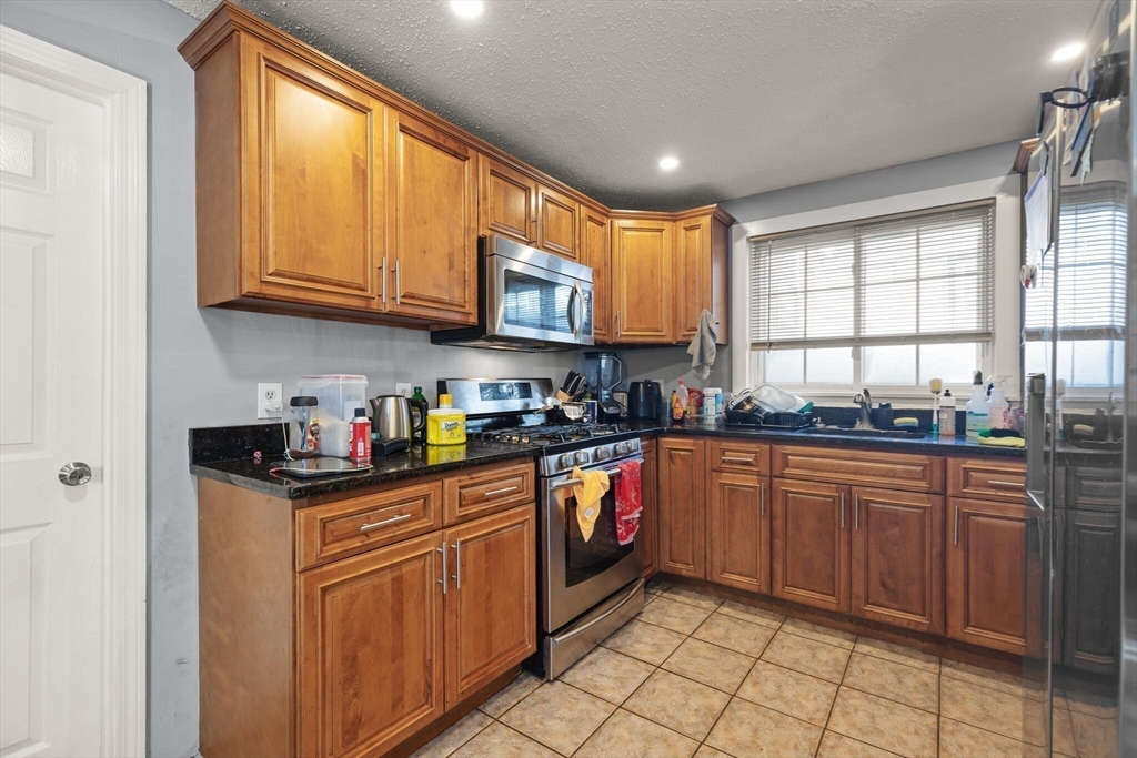 74 Chestnut Street Chelsea, MA 02150 - Photo 15 of 37 a kitchen with stainless steel appliances granite countertop a sink and cabinets