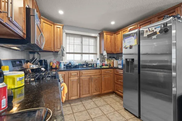 a kitchen with stainless steel appliances granite countertop a refrigerator a stove and a sink with cabinets