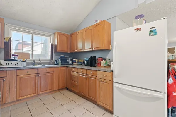 a kitchen with granite countertop appliances a sink and a window