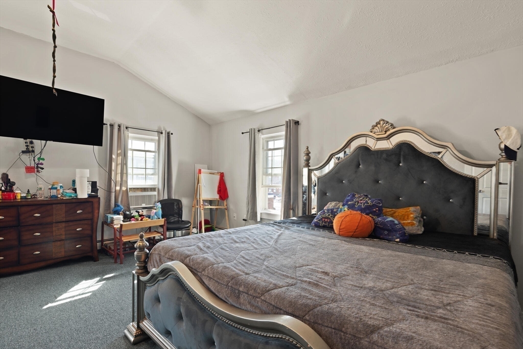 74 Chestnut Street Chelsea, MA 02150 - Photo 19 of 37 a bed room with a bed and a chair