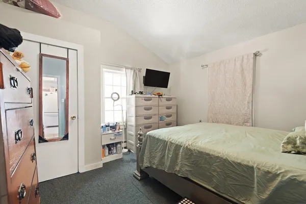 a bedroom with a bed and a flat tv screen