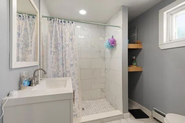 a bathroom with a shower a sink and a mirror