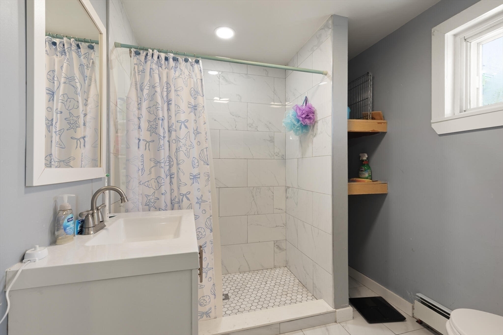 74 Chestnut Street Chelsea, MA 02150 - Photo 25 of 37 a bathroom with a shower a sink and a mirror