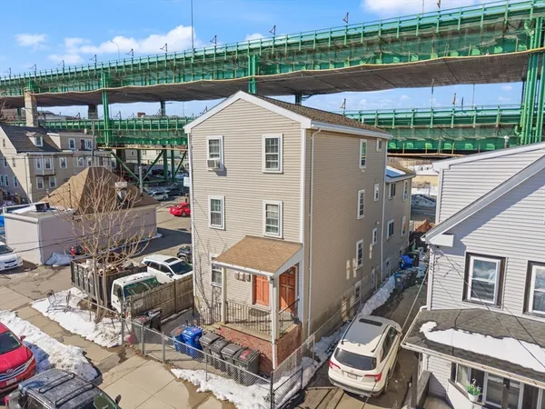 a aerial view of a house with a big yard and potted plants