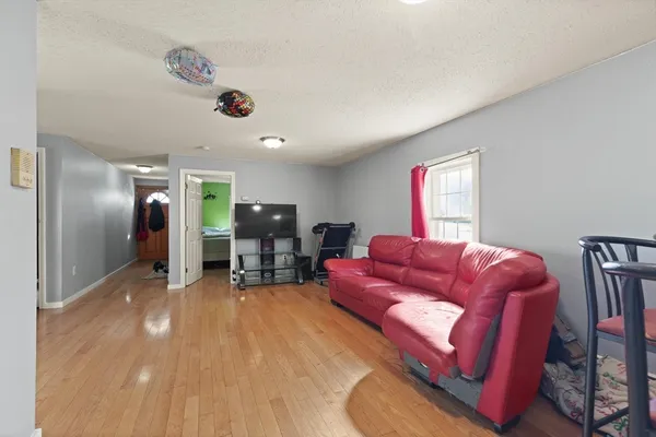 a living room with furniture and a wooden floor